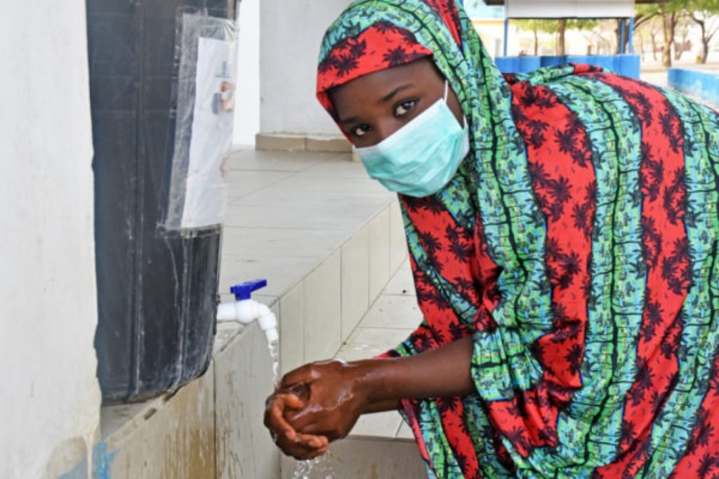 Fatima, 15 washes her hands at IDP camp in Nigeria