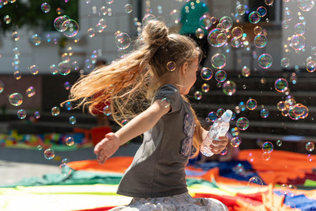 A girl runs through bubbles