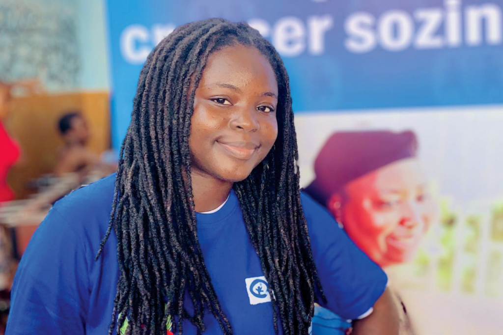 A young woman in a blue tshirt looks at the camera