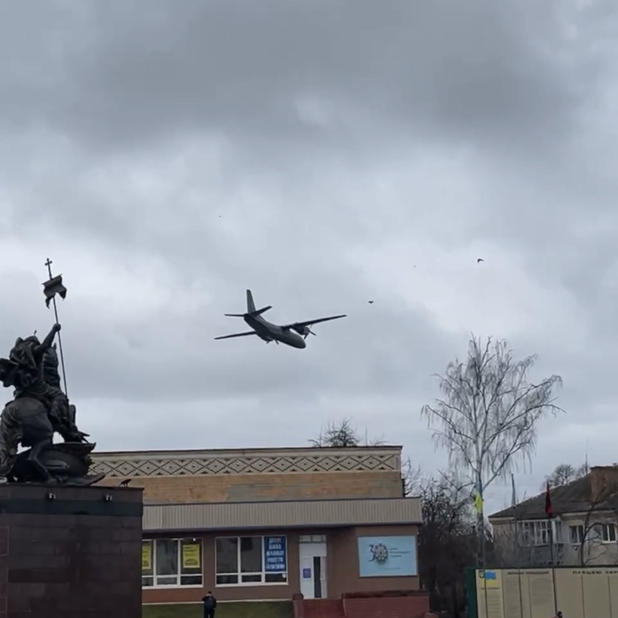 A fighter plane flies over a house