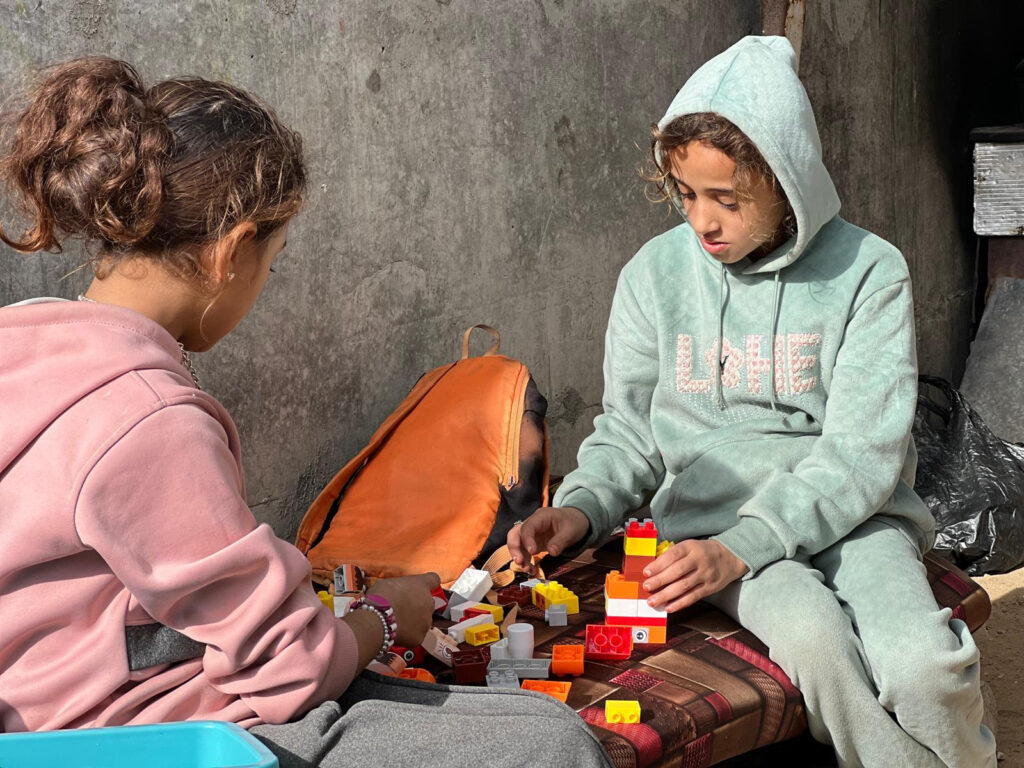 Two girls play with blocks together